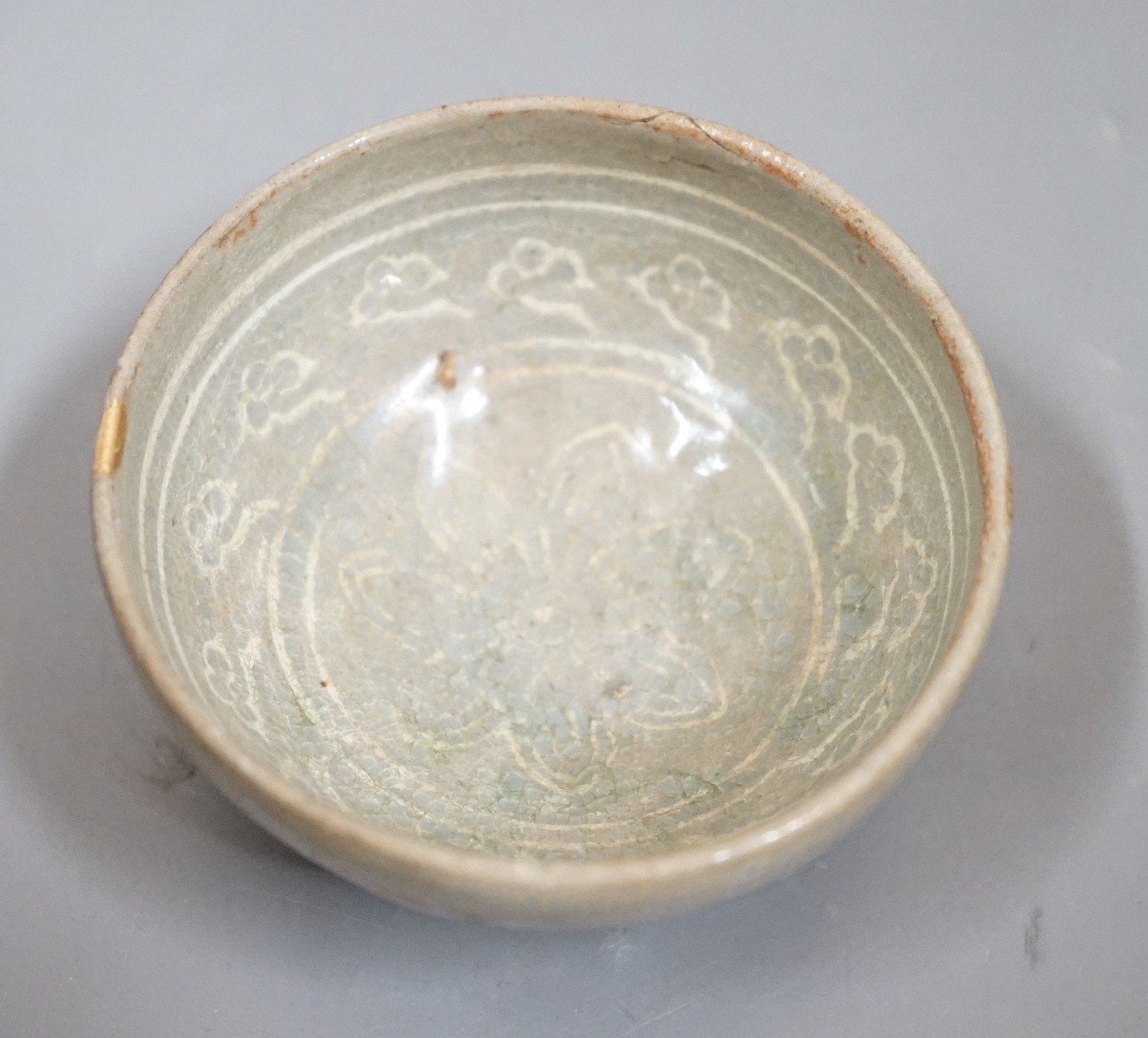 A Korean slip decorated celadon small bowl, Koryo dynasty. 10cm diameter